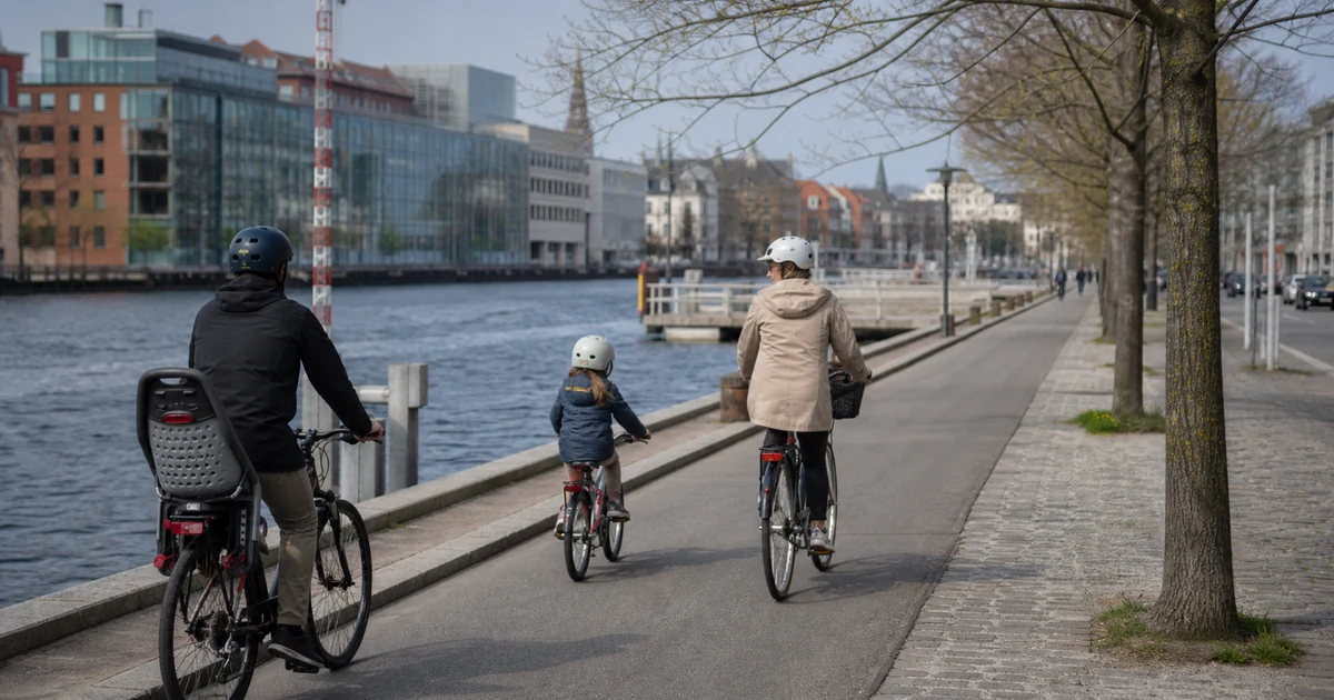 En familie på sykler ved en kanal i København