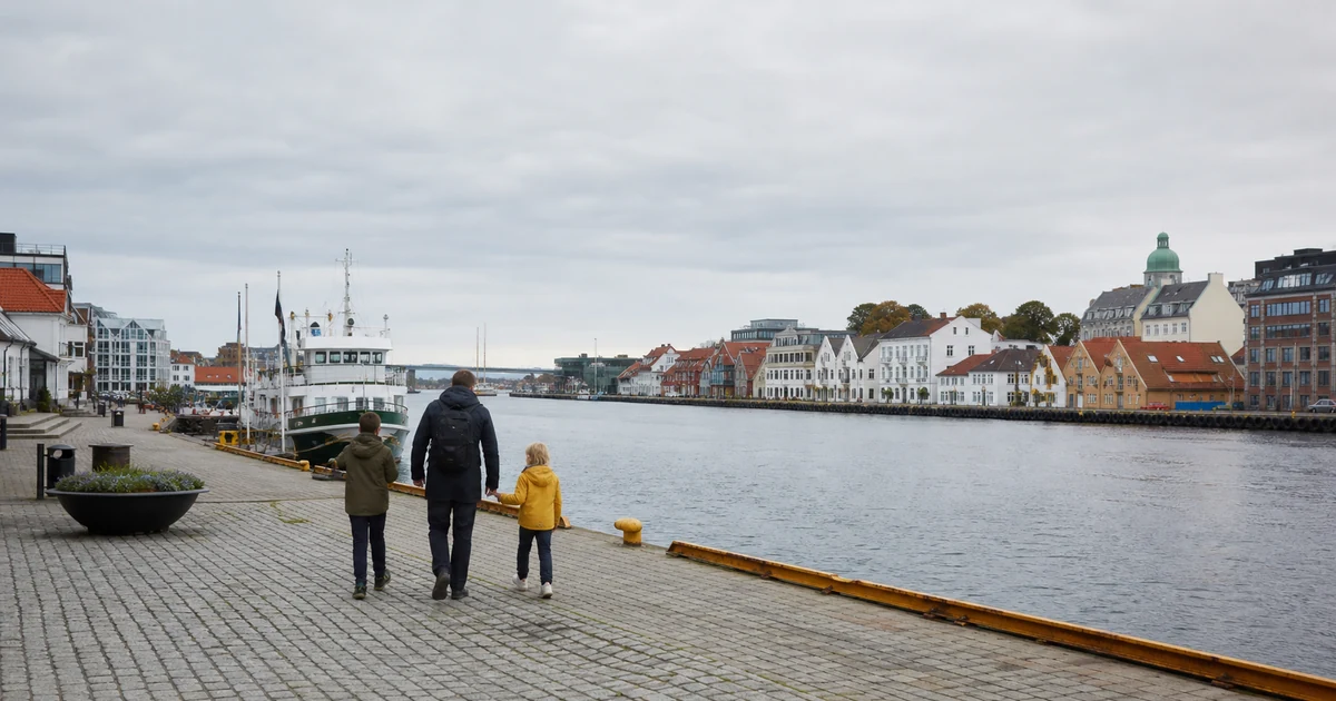 En familie på havnepromenaden i Stavanger på en overskyet dag