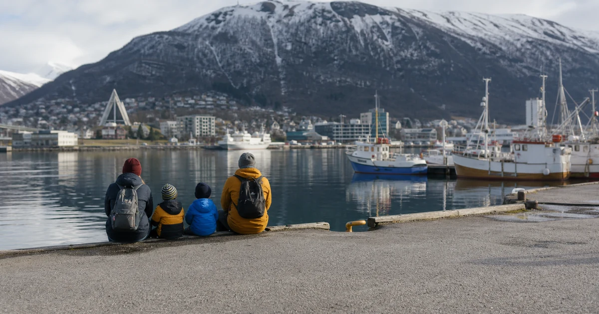 En familie ved en nordnorsk havn med fjell i bakgrunnen