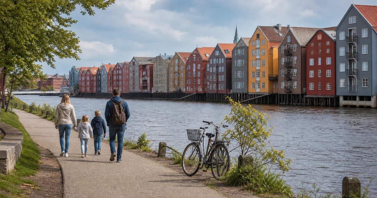 En familie på elvepromenade med fargerike trehus og sykler i Trondheim